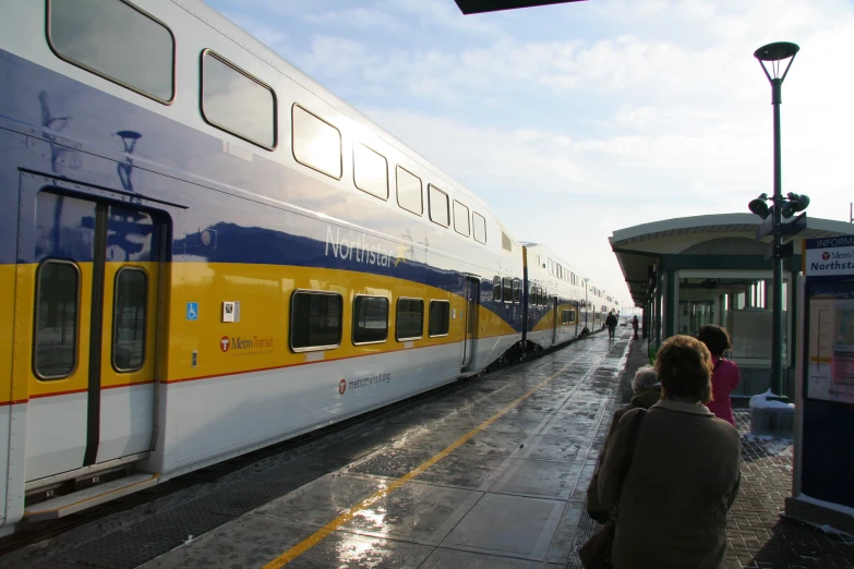 people are standing by the side of a passenger train