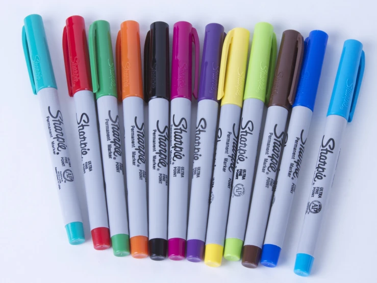 six multi - colored sharpies in assorted colors in a row