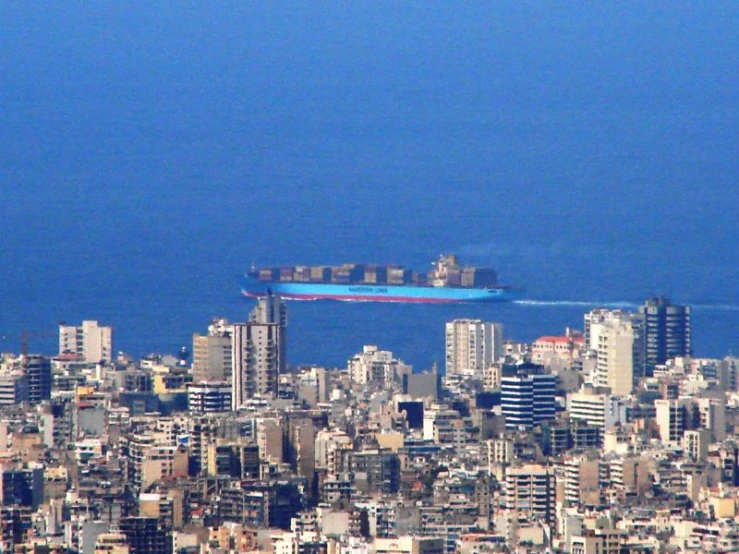 the view of an ocean, city and the ocean from high up in the air