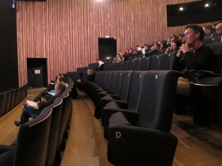 some people sitting in chairs in a large room