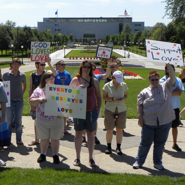 some people holding signs are standing around outside