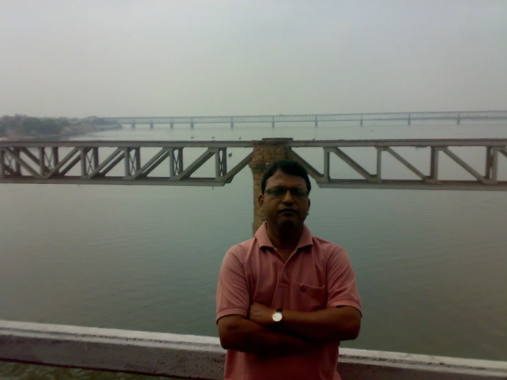 the man is standing by the water posing for a picture