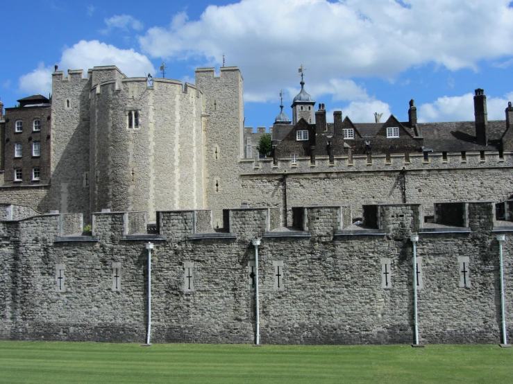 a castle like building next to a tall grass field