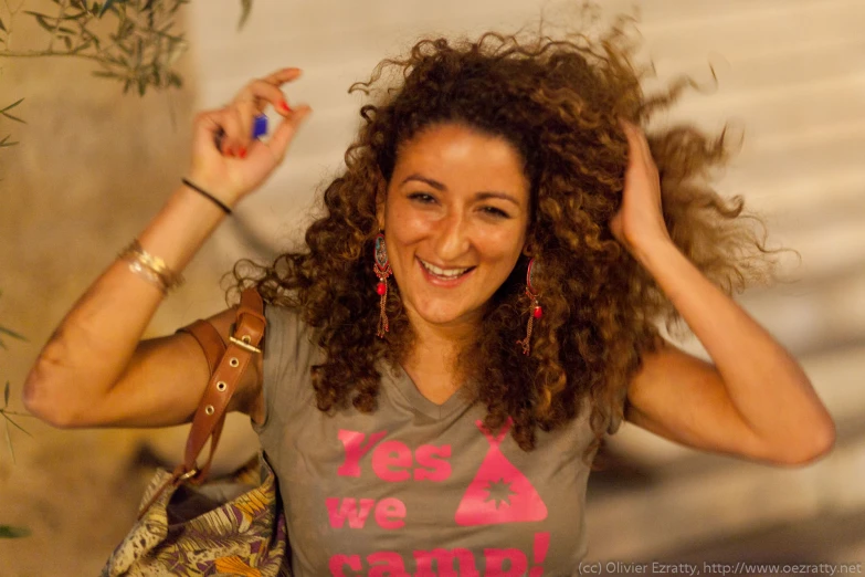 a woman with curly hair wearing a grey shirt