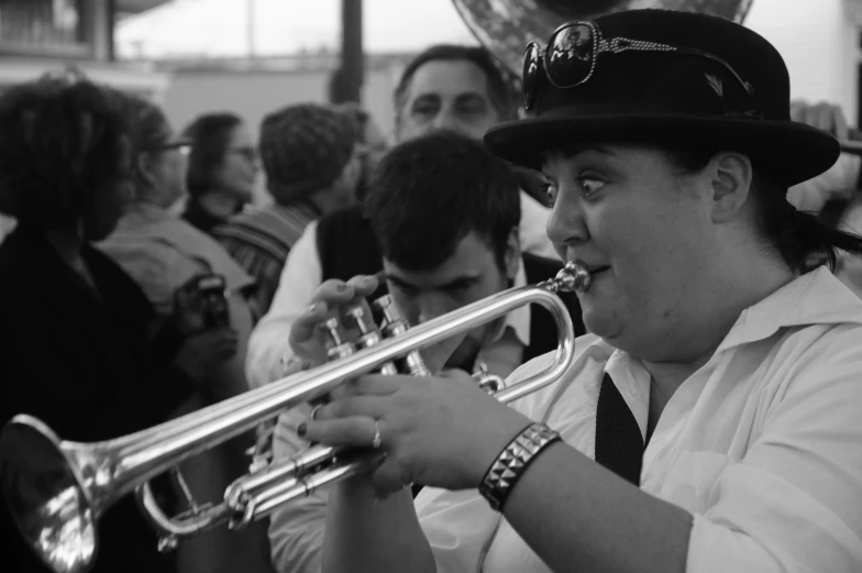 a man wearing a hat playing trumpet on the bus