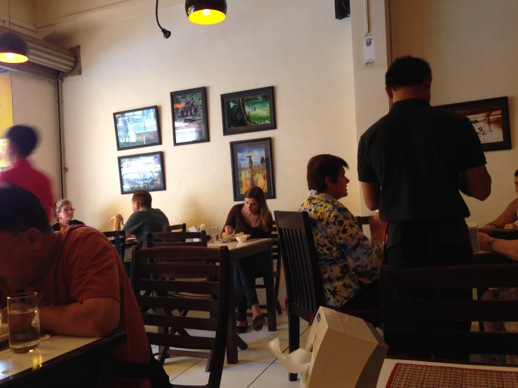 a group of people sitting around tables inside a restaurant