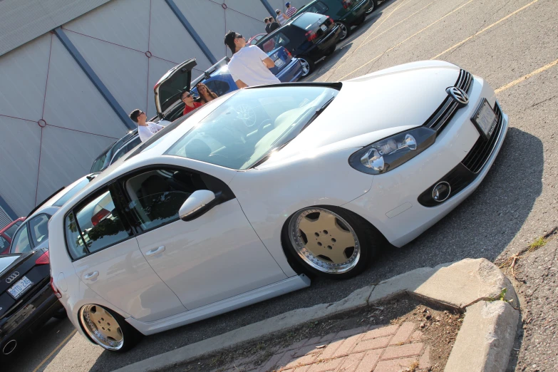 a white car with black face parts sitting on the side of a road