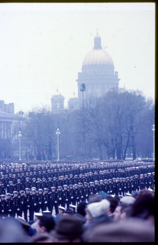 rows of people in winter clothing stand together in the middle of a plaza