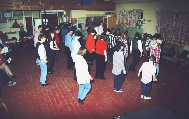 a group of people on a red floor and a white wall