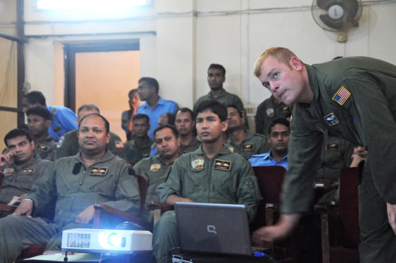 an army officer pointing his laptop at an audience