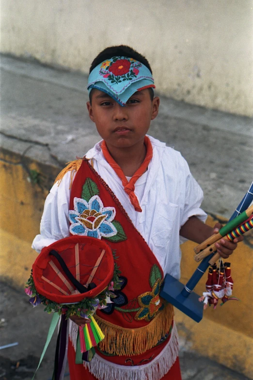 a young man in costume is holding a fan