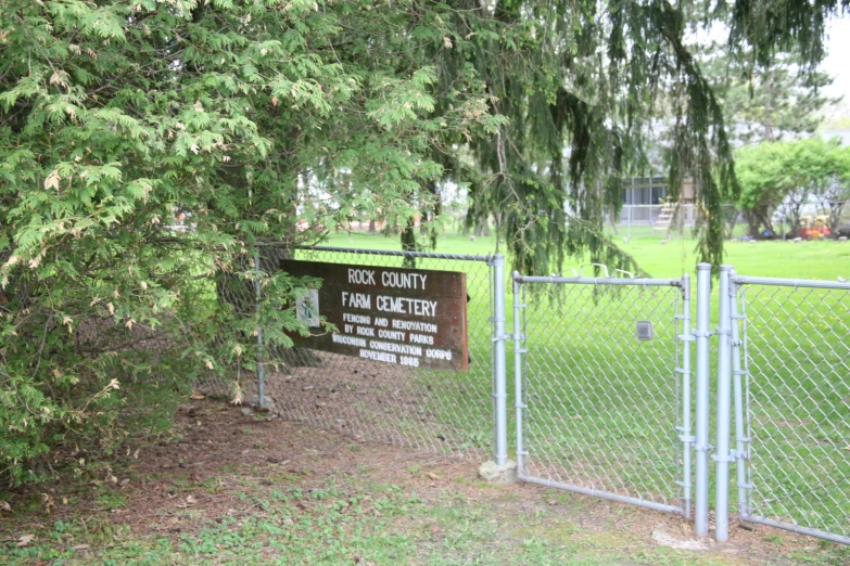 a sign on a fence at an outside park