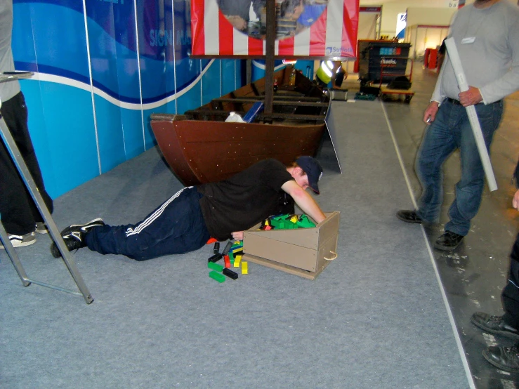 man lying on ground with skateboard under ramp