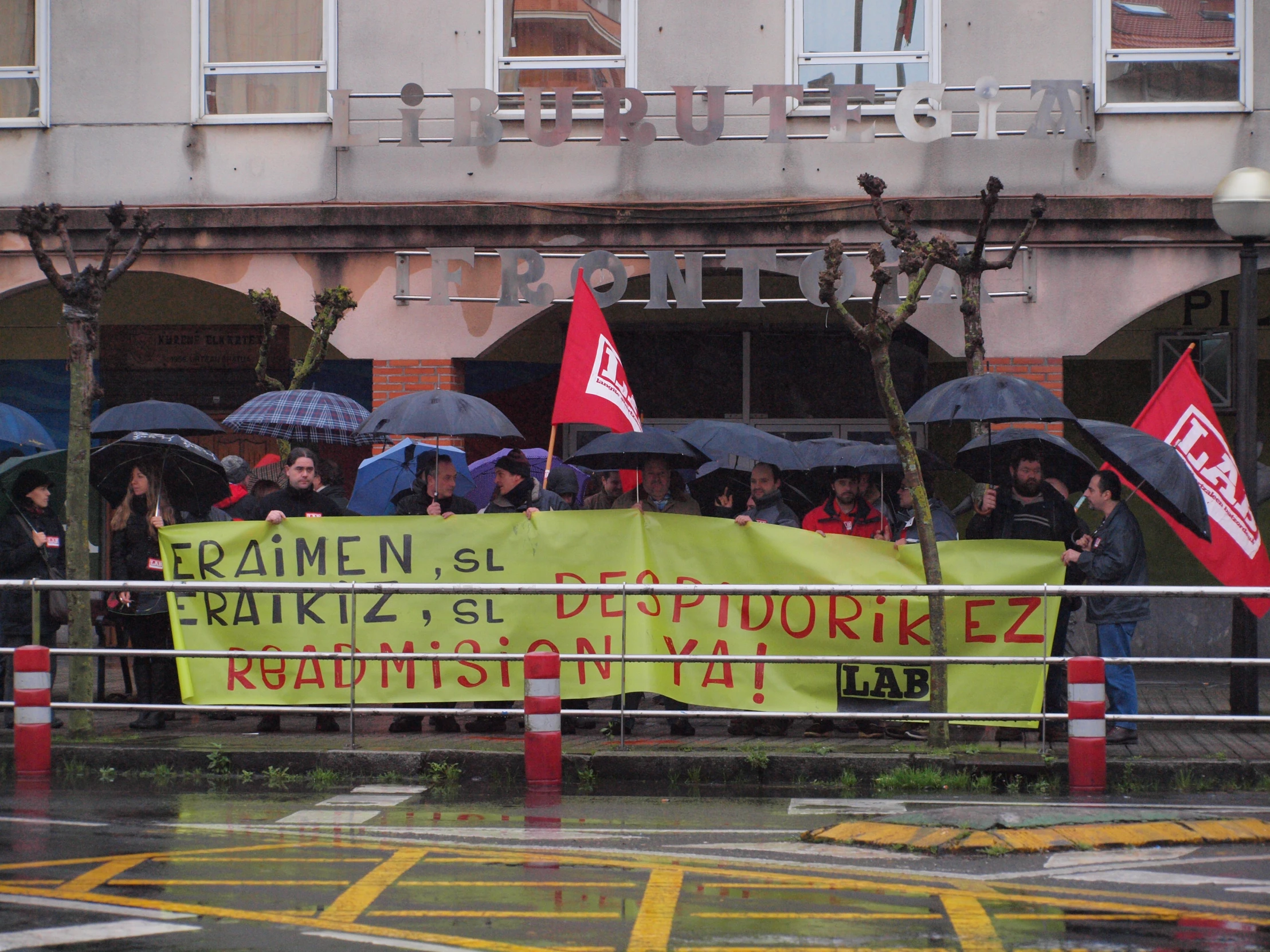 the people are holding a banner in the rain