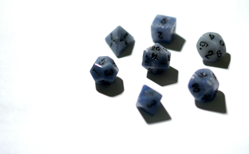 six pieces of blue dice sitting on top of a white table