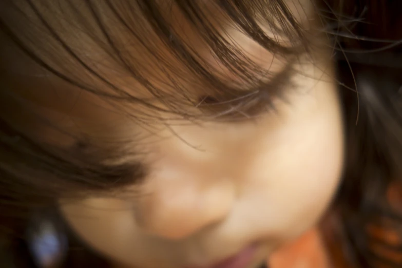 small child with dark brown hair looks to her left