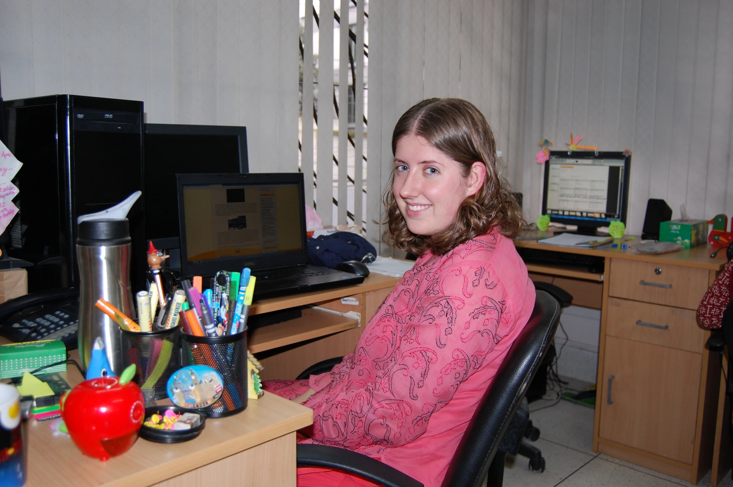 a woman sitting in an office chair in front of a desk