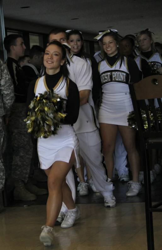 some cheerleaders and a soldier are holding their guns