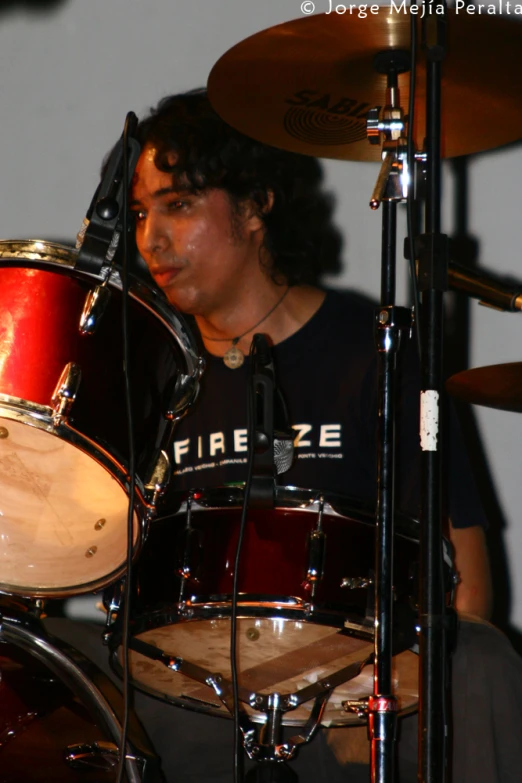 a young person playing the drums in front of a microphone