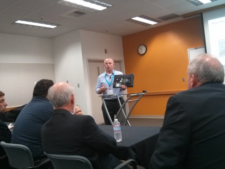 a man giving a presentation to his colleagues in a seminar hall