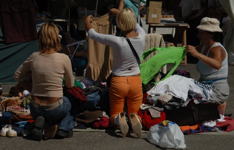 two women are picking things from a tent