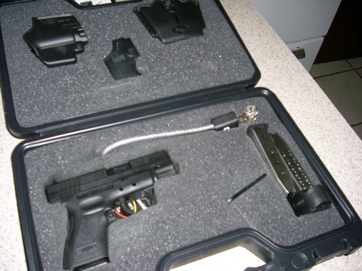 two guns and other items are displayed in a suitcase