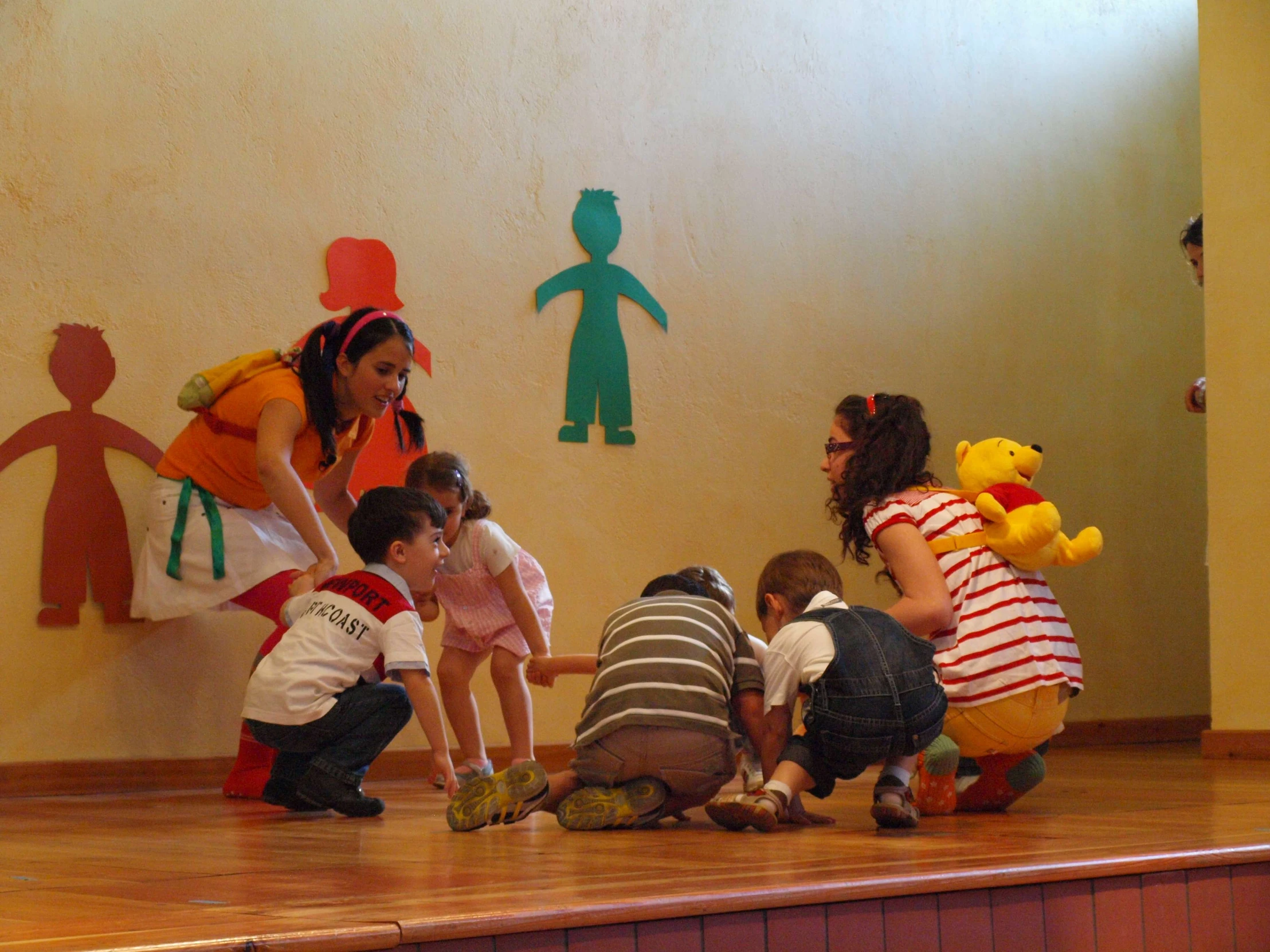 several children and adults in costumes on stage