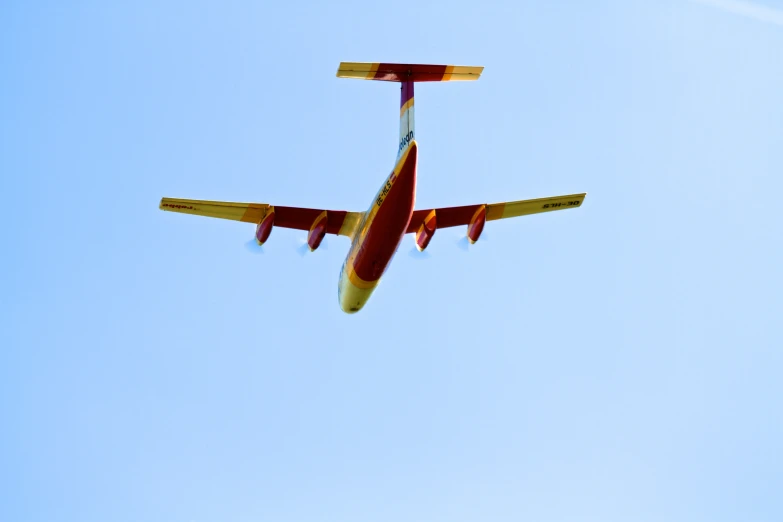 an orange and white plane flying across the sky