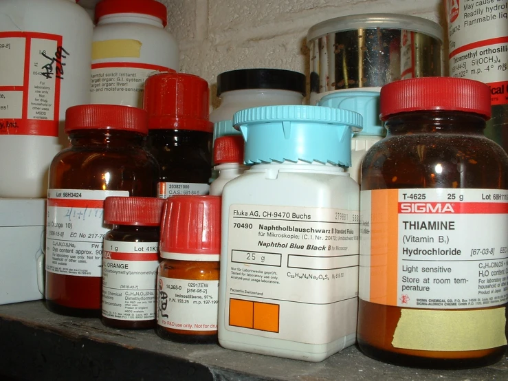 several pills on top of a shelf next to medicine bottles