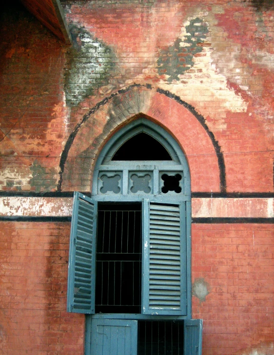 a building with a clock, a window and shutters
