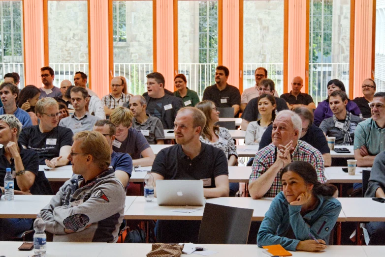 a group of people at a meeting with their laptop computers