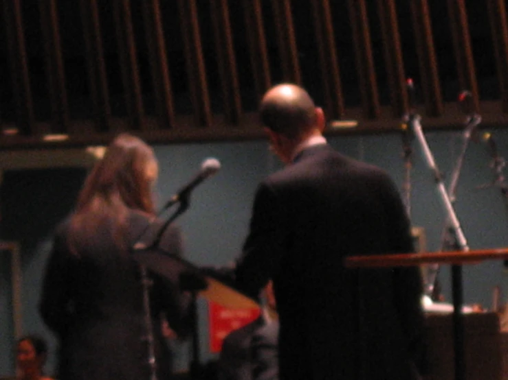 a man in a suit stands at a podium with a microphone