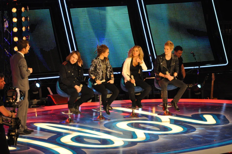 a group of people sitting down on stools