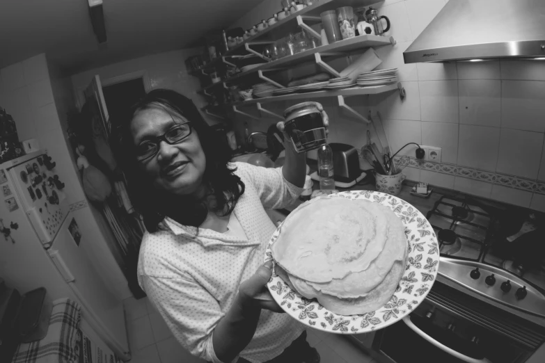 a person holds a cake on top of a plate in a kitchen