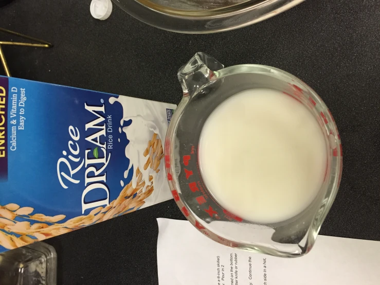 a bowl of milk next to a carton of rice