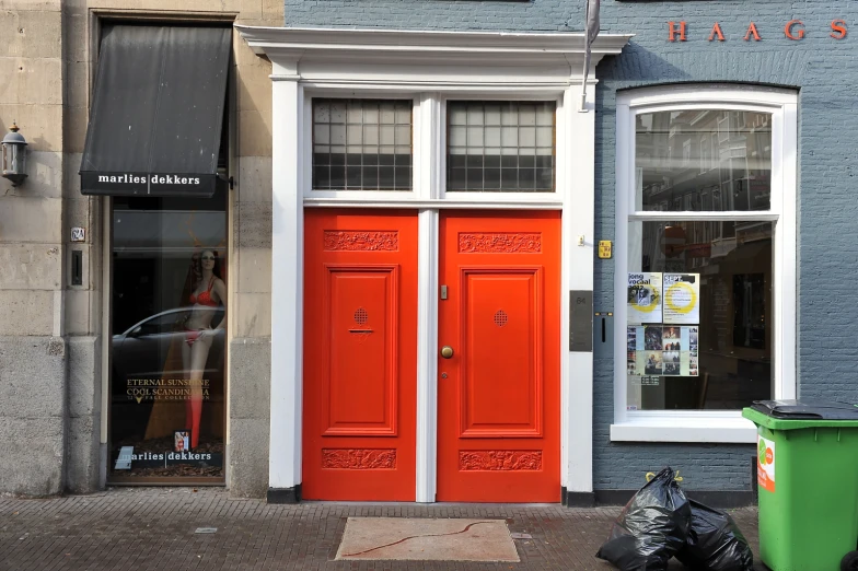 a couple of red doors sitting outside of a store