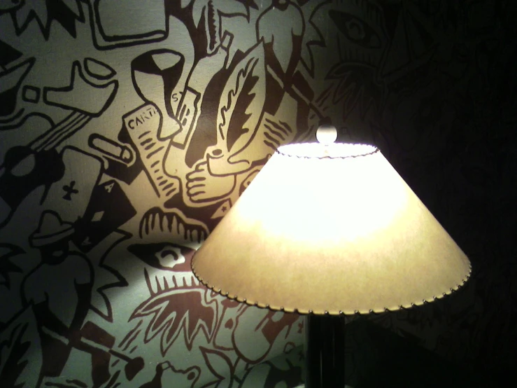 a lamp sitting on a table next to a wall with graffiti