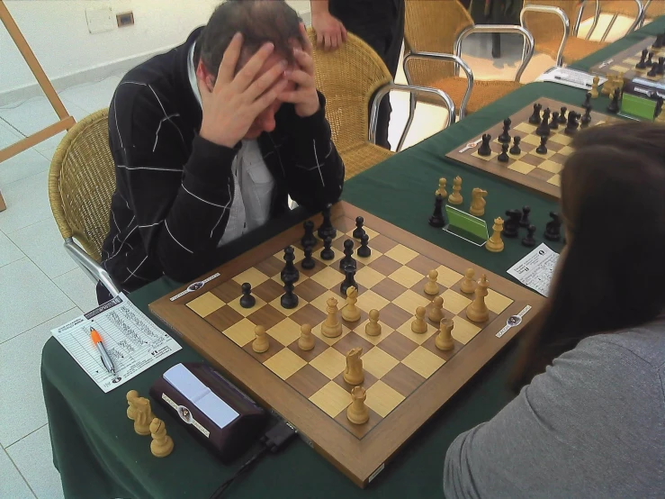 a man playing chess while people watch