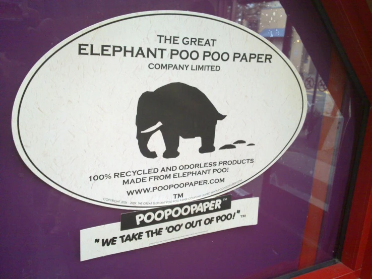 a sign that says elephant poo poo paper is posted on a purple wall