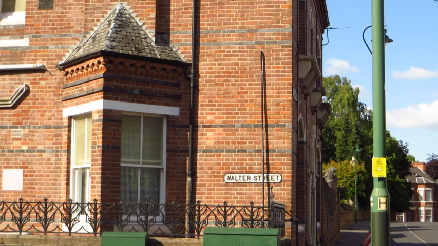 brick building in front of a street corner with a street sign