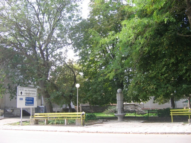 several benches and a sign on a road side