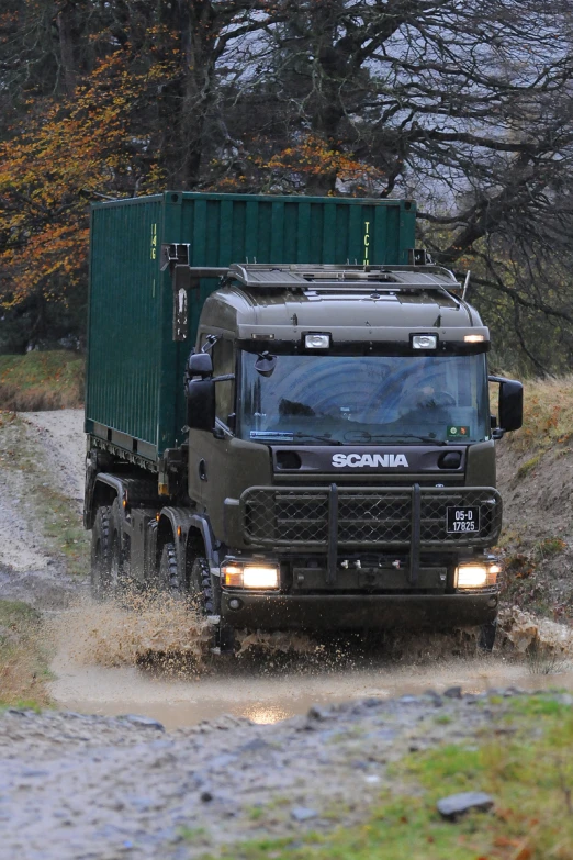 a big truck driving down a muddy road