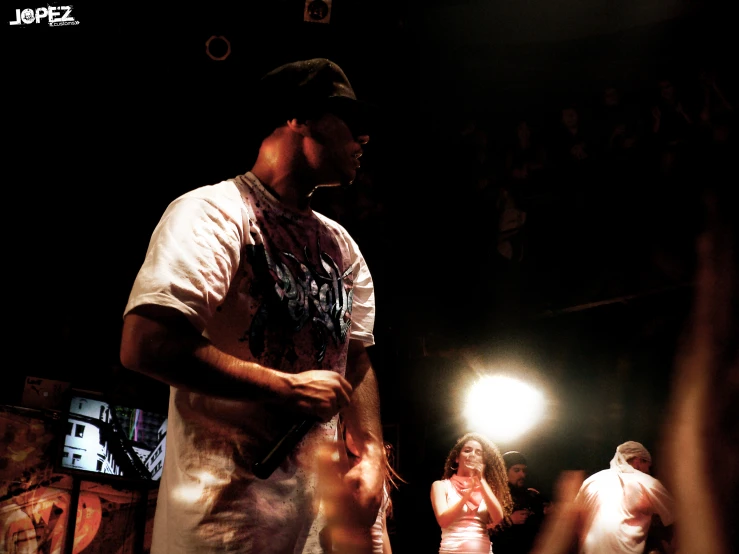 a man holding a bottle standing on top of a stage