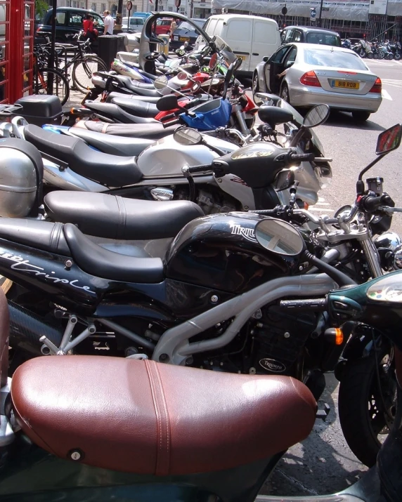 many motorcycles are parked together in front of the street