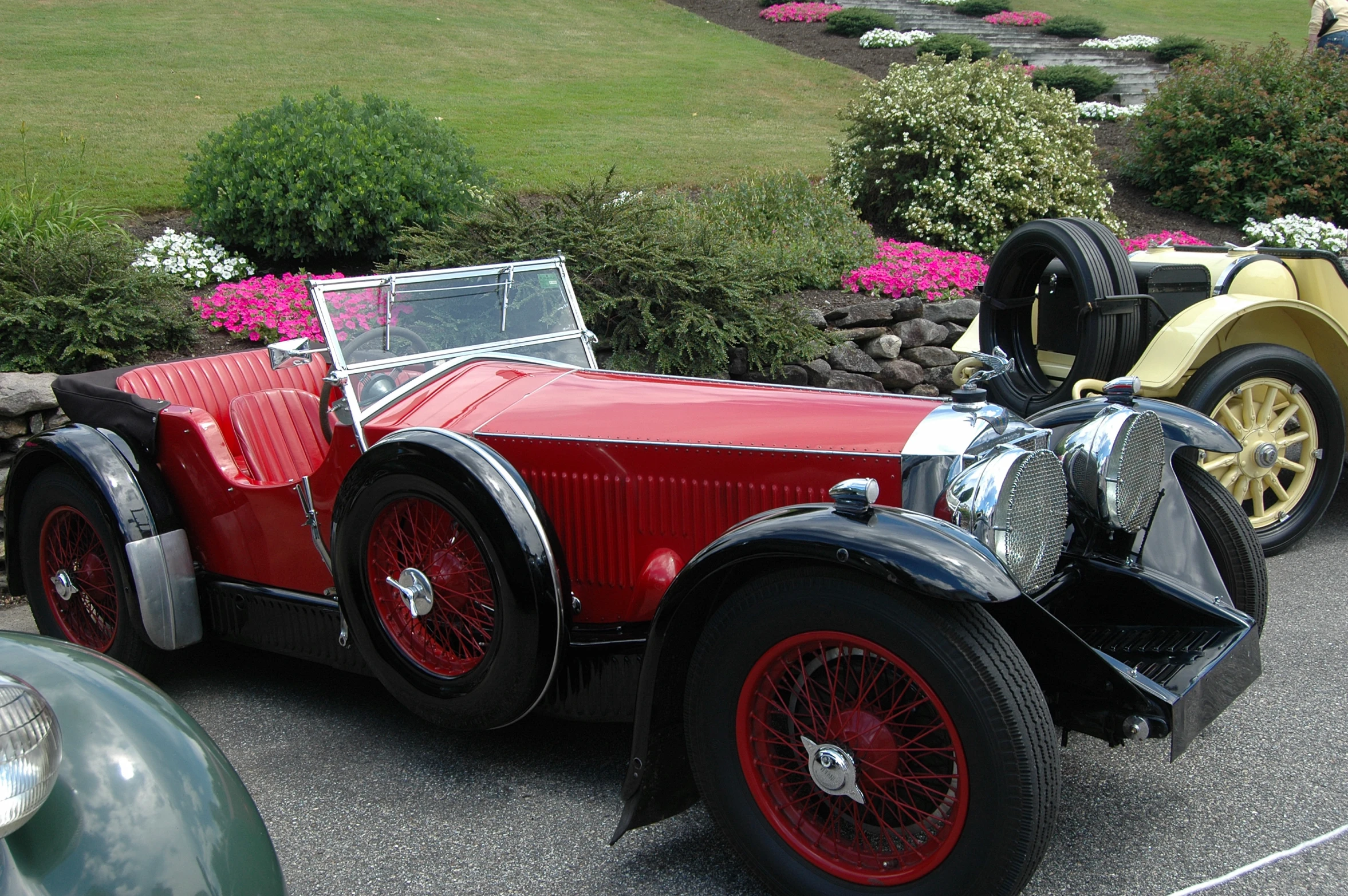 there is a car and another vintage car parked in the street