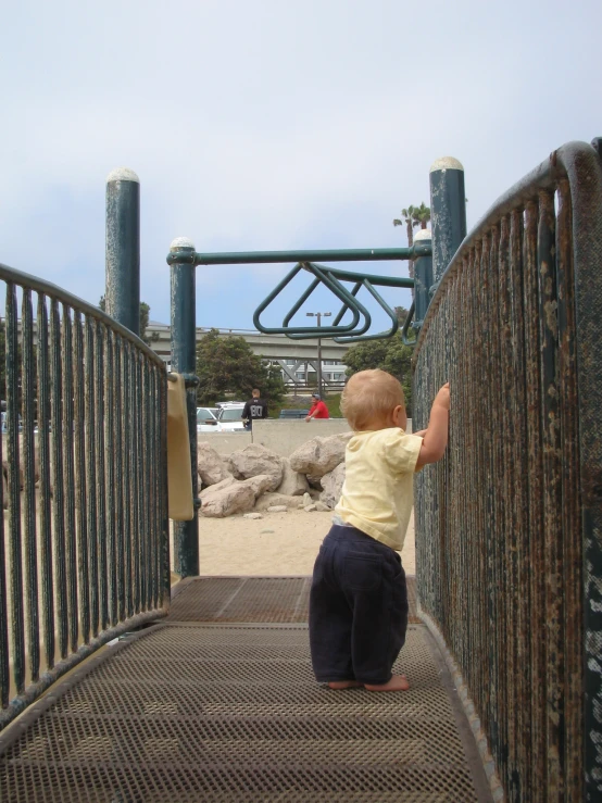 a toddler climbing a set of stairs at a park