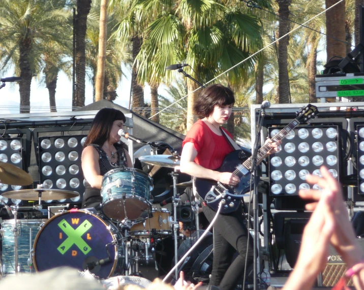 a boy playing on a guitar near other people