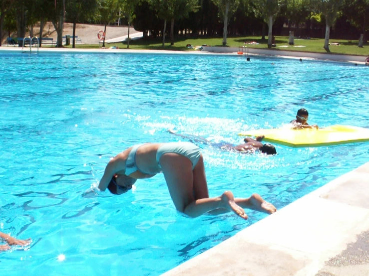 three young people are having fun in a pool