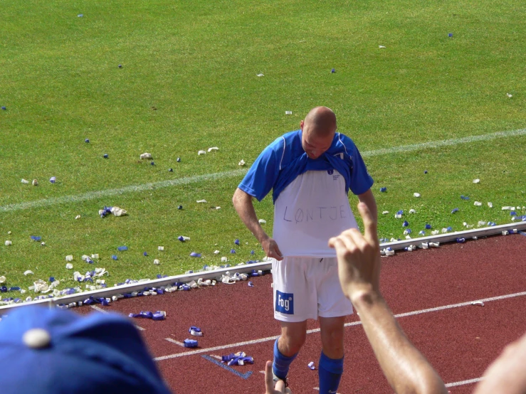 the coach gives a thumbs up as he stands on the soccer field