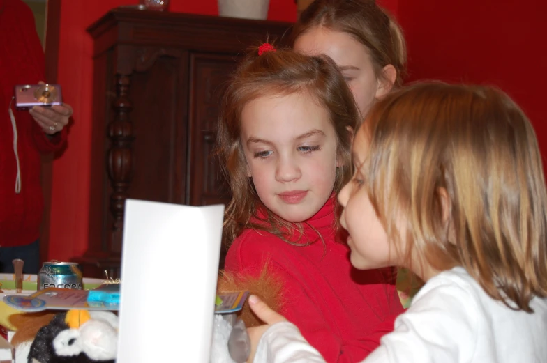 three children and one is using a laptop